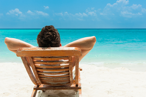 Man relaxing on beach, ocean view, Maldives island